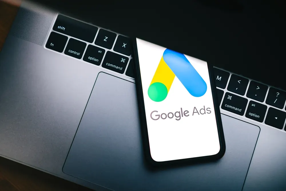 Google Ads op een smartphone naast een laptop